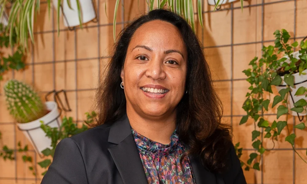 Coach Jessica Meijers drinkt een kopje koffie met planten op de achtergrond